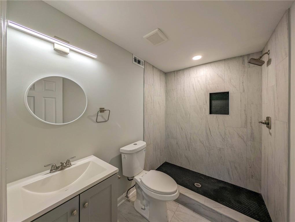 610 Glenforest Road Atlanta, GA 30328 - Photo 37 of 44 a bathroom with a toilet a sink a mirror and a shower