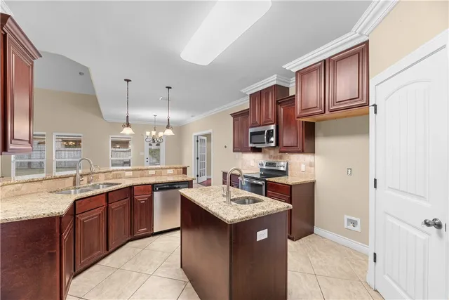 a kitchen with stainless steel appliances kitchen island granite countertop a sink dishwasher stove and cabinets