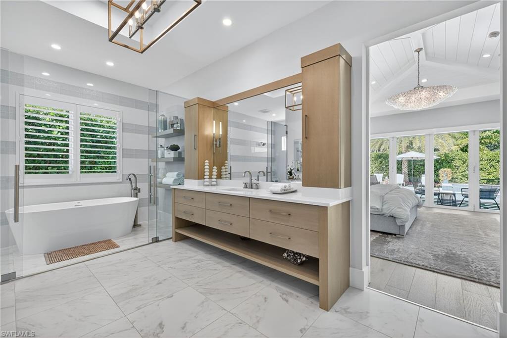 405 7th Avenue North Naples, FL 34102 - Photo 22 of 50 a bathroom with a double vanity sink bathtub and next to a window