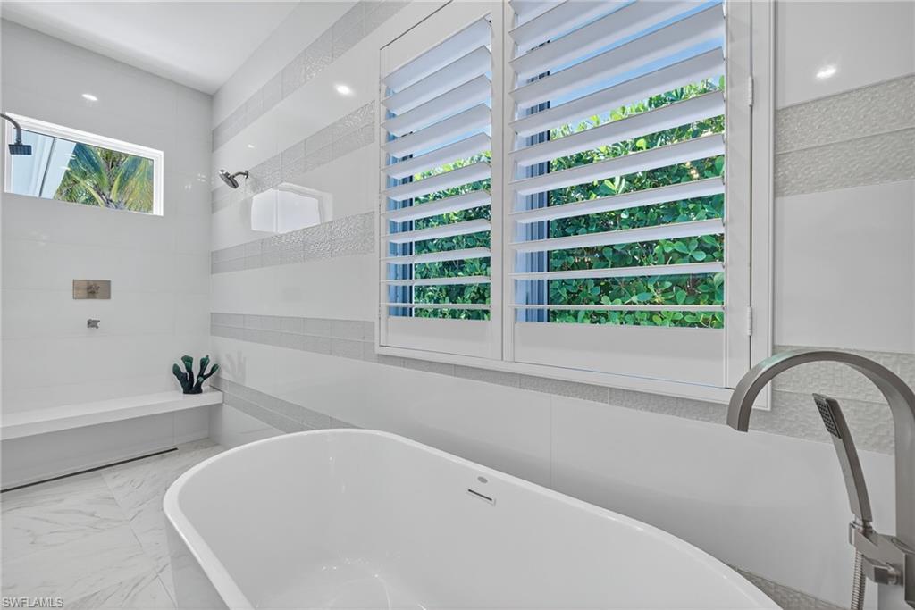 405 7th Avenue North Naples, FL 34102 - Photo 23 of 50 a bathroom with a bathtub and a window