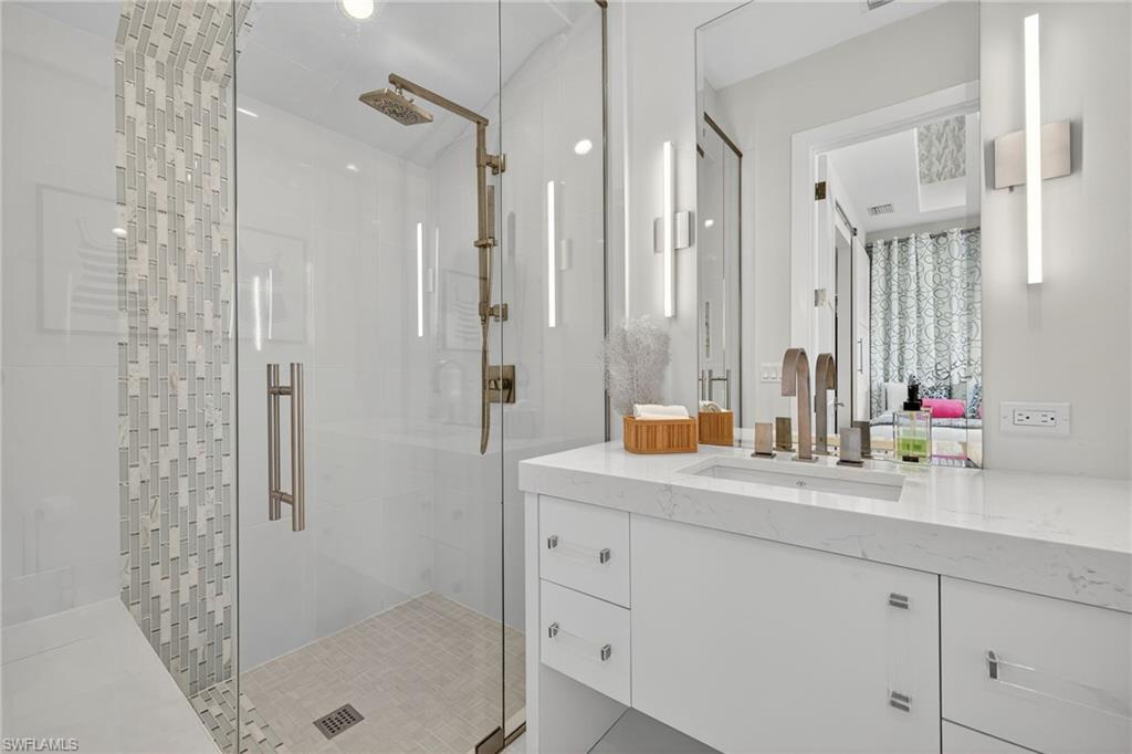 405 7th Avenue North Naples, FL 34102 - Photo 35 of 50 a bathroom with a granite countertop sink mirror and shower