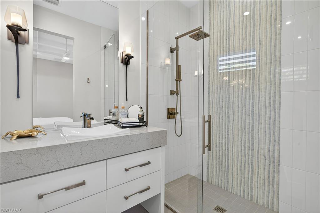 405 7th Avenue North Naples, FL 34102 - Photo 38 of 50 a bathroom with a sink a mirror and shower