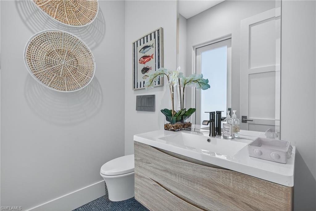 405 7th Avenue North Naples, FL 34102 - Photo 39 of 50 a bathroom with a toilet a sink and a mirror