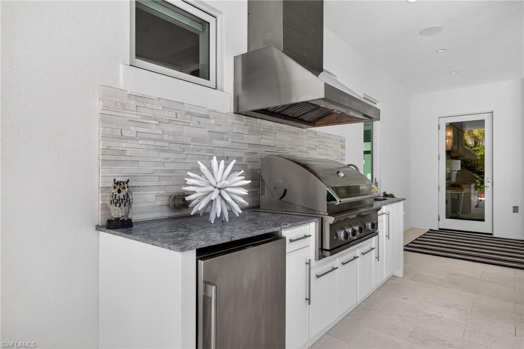 405 7th Avenue North Naples, FL 34102 - Photo 42 of 50 a kitchen with stainless steel appliances granite countertop a stove and a microwave
