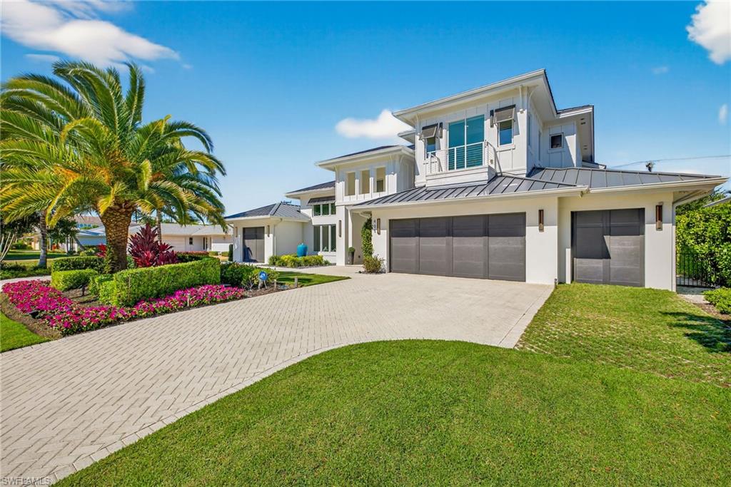405 7th Avenue North Naples, FL 34102 - Photo 46 of 50 a front view of a house with a garden and yard