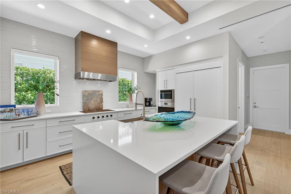 405 7th Avenue North Naples, FL 34102 - Photo 9 of 50 a kitchen with a dining table chairs and refrigerator