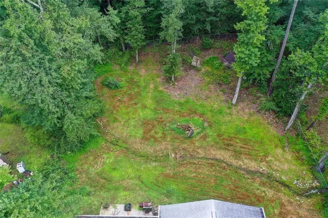 an aerial view of house with yard and trees in the background