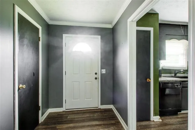 a view of a hallway with wooden floor and a bathroom