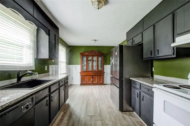 a kitchen with stainless steel appliances a sink dishwasher stove and refrigerator