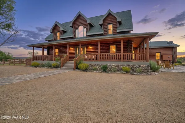 a front view of a house with a yard and potted plants