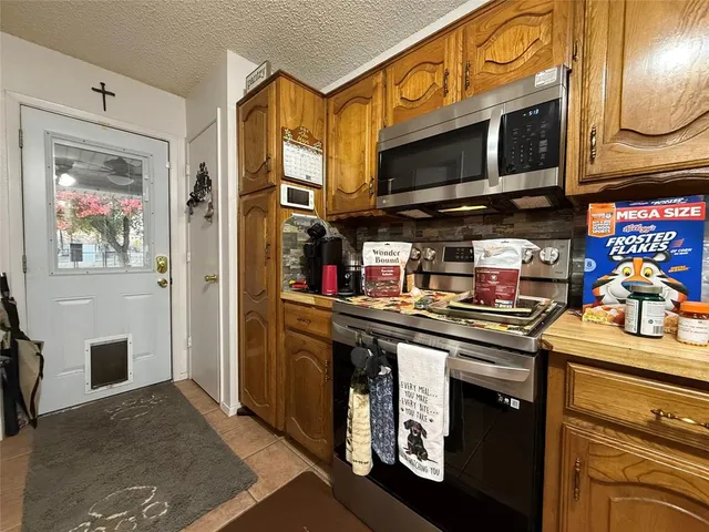 a kitchen with stainless steel appliances kitchen island granite countertop a refrigerator and microwave