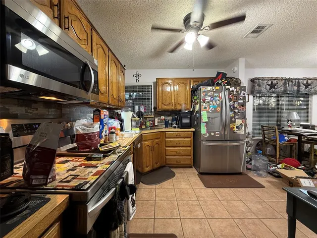 a roof deck with table and chairs and potted plants