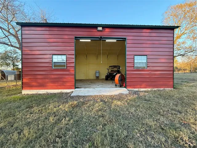 a view of barn with big yard and large trees