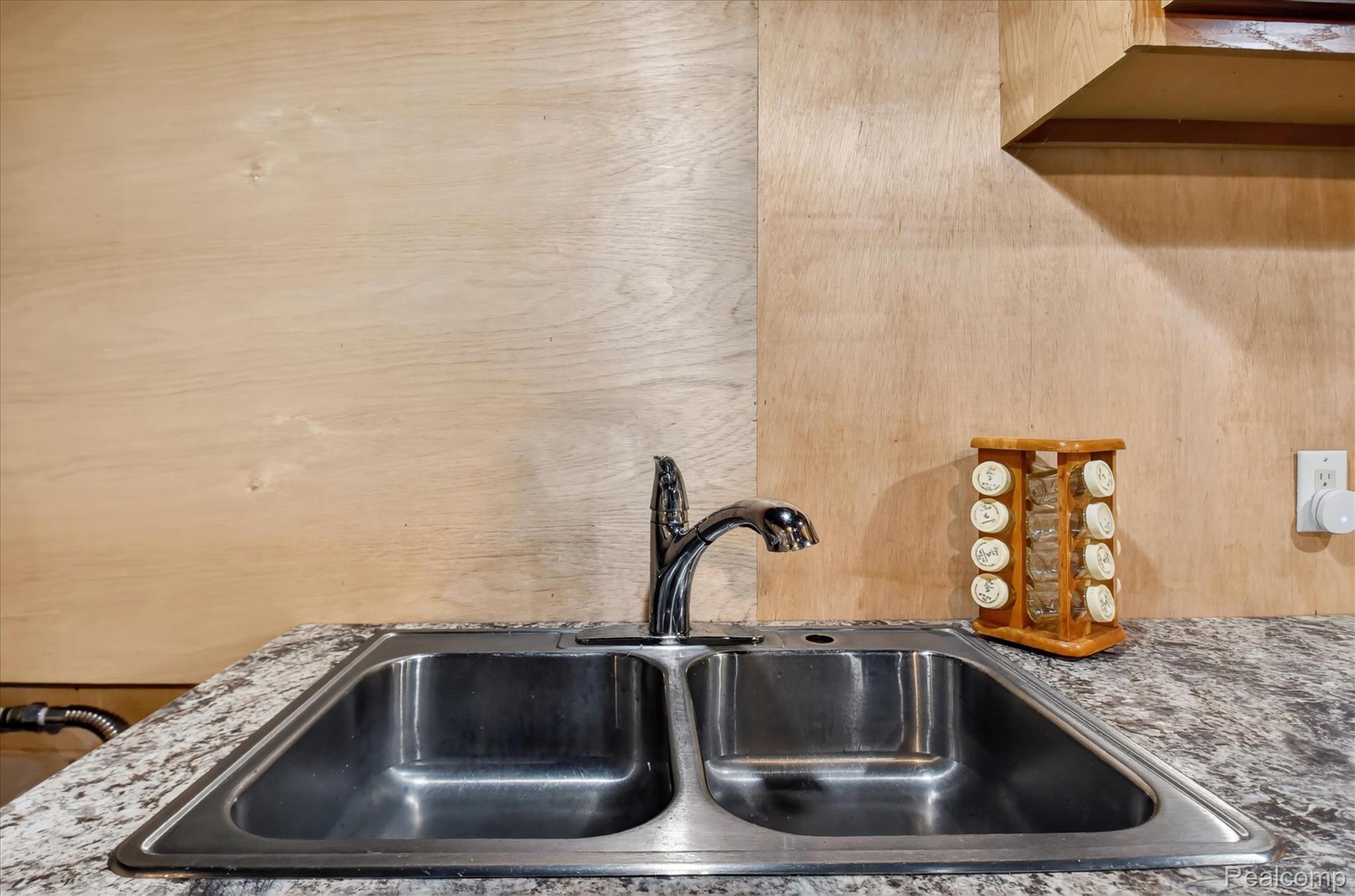 3949 West Burns Line Road Brown City, MI 48416 - Photo 49 of 70 Dual basin stainless steel sink with a chrome faucet, set into a speckled countertop
