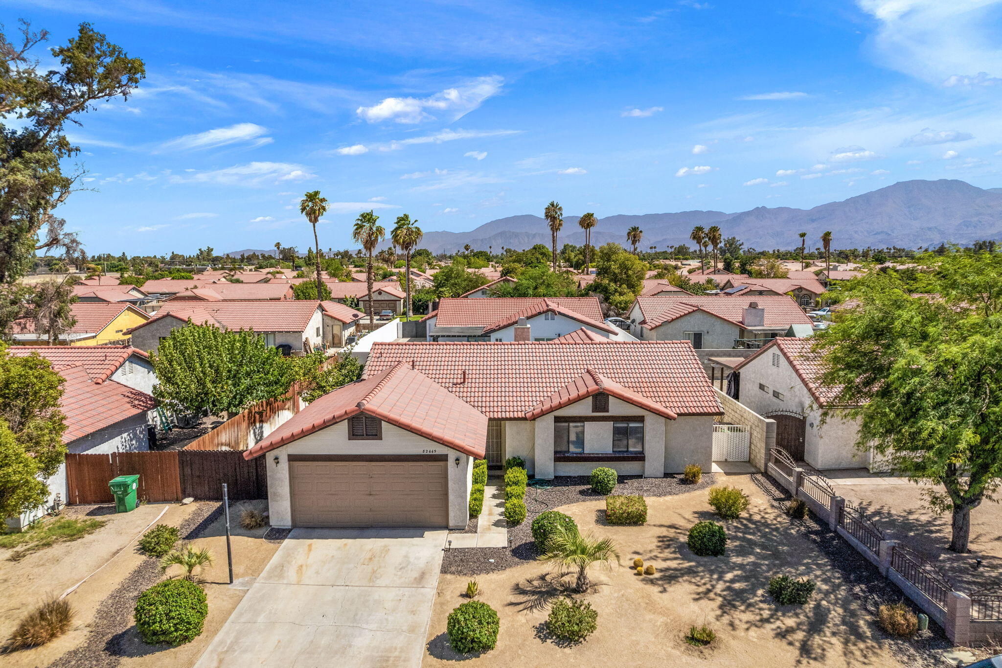 a view of a big house with a big yard and large trees
