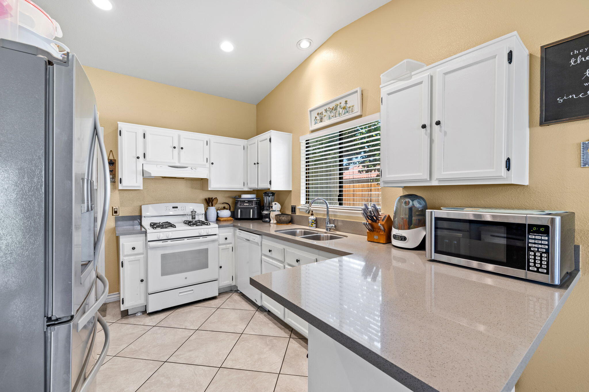 82445 Arlene Drive Indio, CA 92201 - Photo 4 of 18 a kitchen with granite countertop white cabinets and white appliances