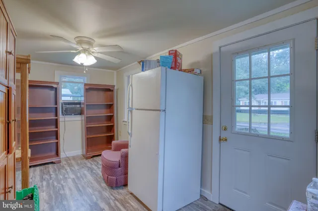 a living room with furniture a chandelier a large window and a flat screen tv