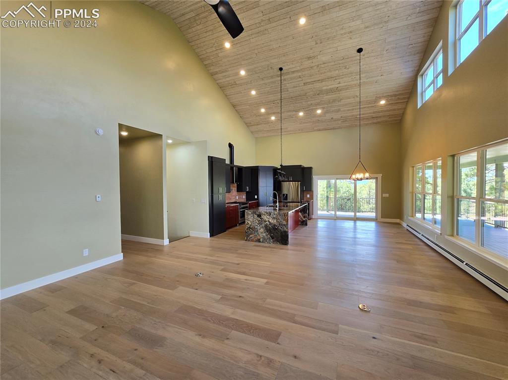 33036 Meadow Ridge Lane Trinidad, CO 81082 - Photo 16 of 50 Living room featuring high vaulted ceiling, open kitchen/dining, and light hardwood / wood-style floors