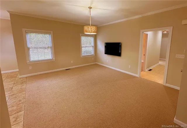 an empty room with windows and fireplace