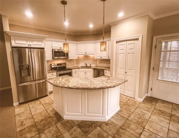 a kitchen with stainless steel appliances granite countertop a sink a refrigerator and a stove