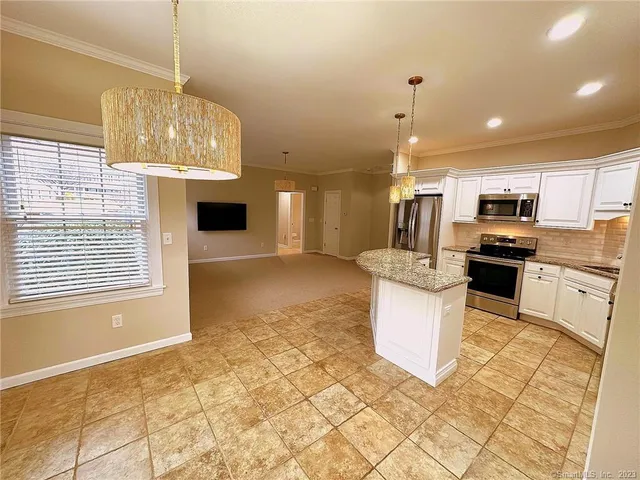 a kitchen with stainless steel appliances granite countertop a stove top oven a sink dishwasher and a refrigerator