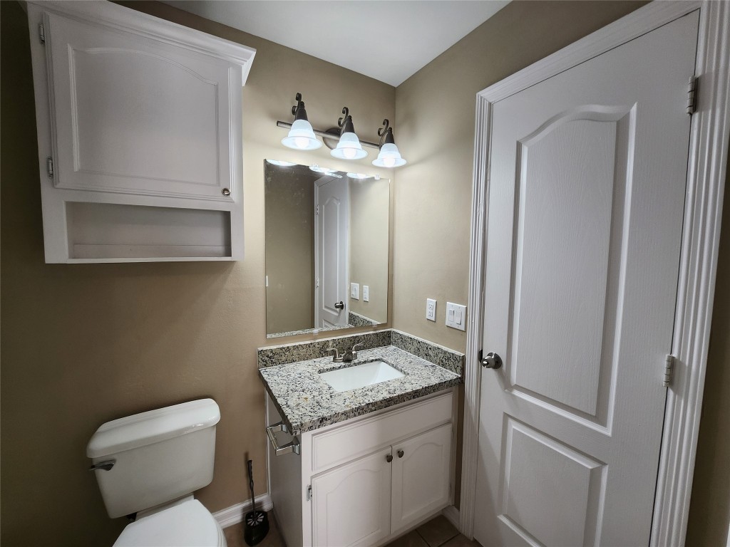 7609 Villa Rama S Street, Unit 4 Mission, TX 78572 - Photo 8 of 11 a bathroom with a granite countertop toilet sink and mirror
