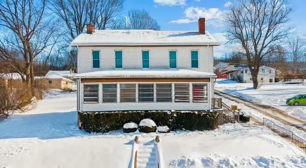 a front view of a house with a yard covered in snow