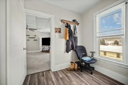 a view of a workspace with furniture and a window