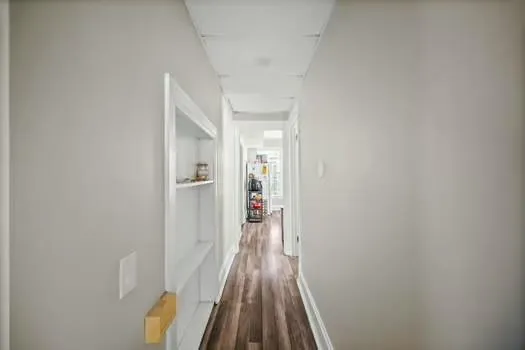 a view of a hallway with wooden floor