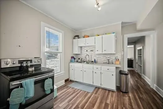 a kitchen with granite countertop a stove sink and cabinets