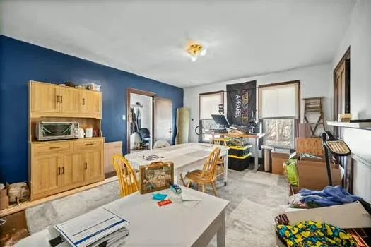 a very nice looking dining room with kitchen island furniture a rug a kitchen view and a window