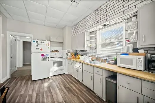 a kitchen that has a lot of cabinets and wooden floor