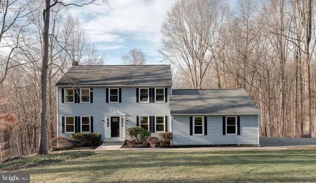 a front view of house with yard and trees around