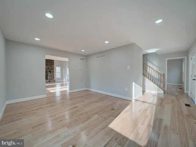 a view of empty room with wooden floor and fireplace