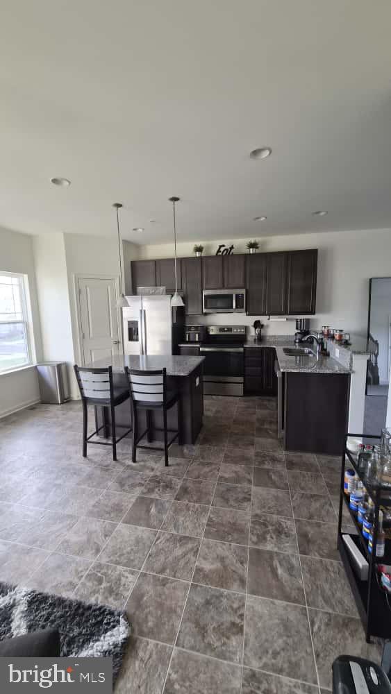 2488 Westwind Boulevard Cambridge, MD 21613 - Photo 13 of 32 a living room with stainless steel appliances kitchen island granite countertop a stove a sink a table and chairs