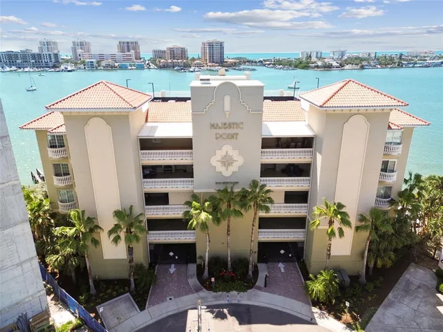 a dining hall with stainless steel appliances kitchen island granite countertop a table chairs and a chandelier