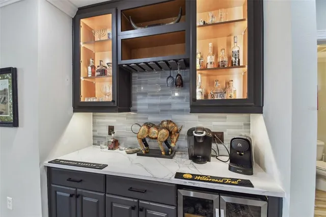 a living room with stainless steel appliances kitchen island granite countertop a sink and a fireplace