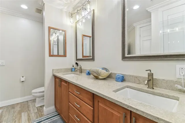 a bathroom with a granite countertop sink a toilet a shower curtain and a bath tub