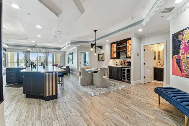 a kitchen with stainless steel appliances granite countertop wooden cabinets a sink dishwasher a stove and a refrigerator with wooden floor