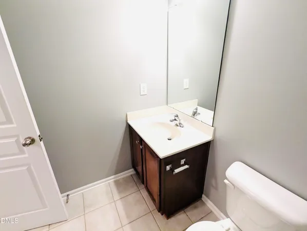 a utility room with a sink a toilet and mirror