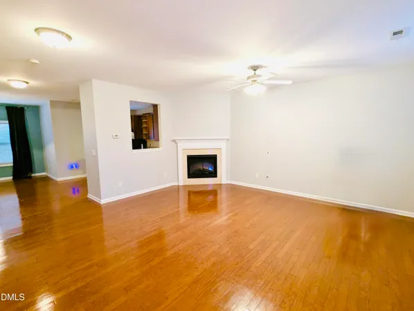 an empty room with a fireplace and a ceiling fan