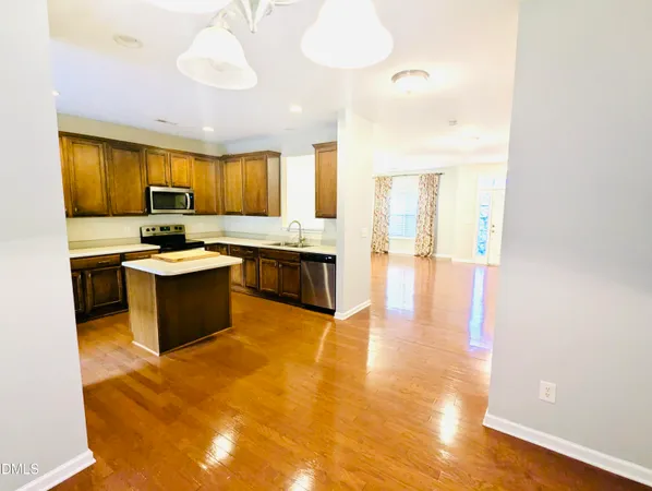 a kitchen with granite countertop a sink cabinets and stainless steel appliances
