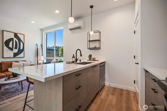 a kitchen with stainless steel appliances granite countertop a sink a stove and a wooden floor