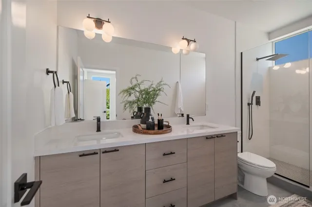 a bathroom with a double vanity sink toilet and shower
