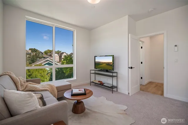 a living room with furniture a window and a flat screen tv