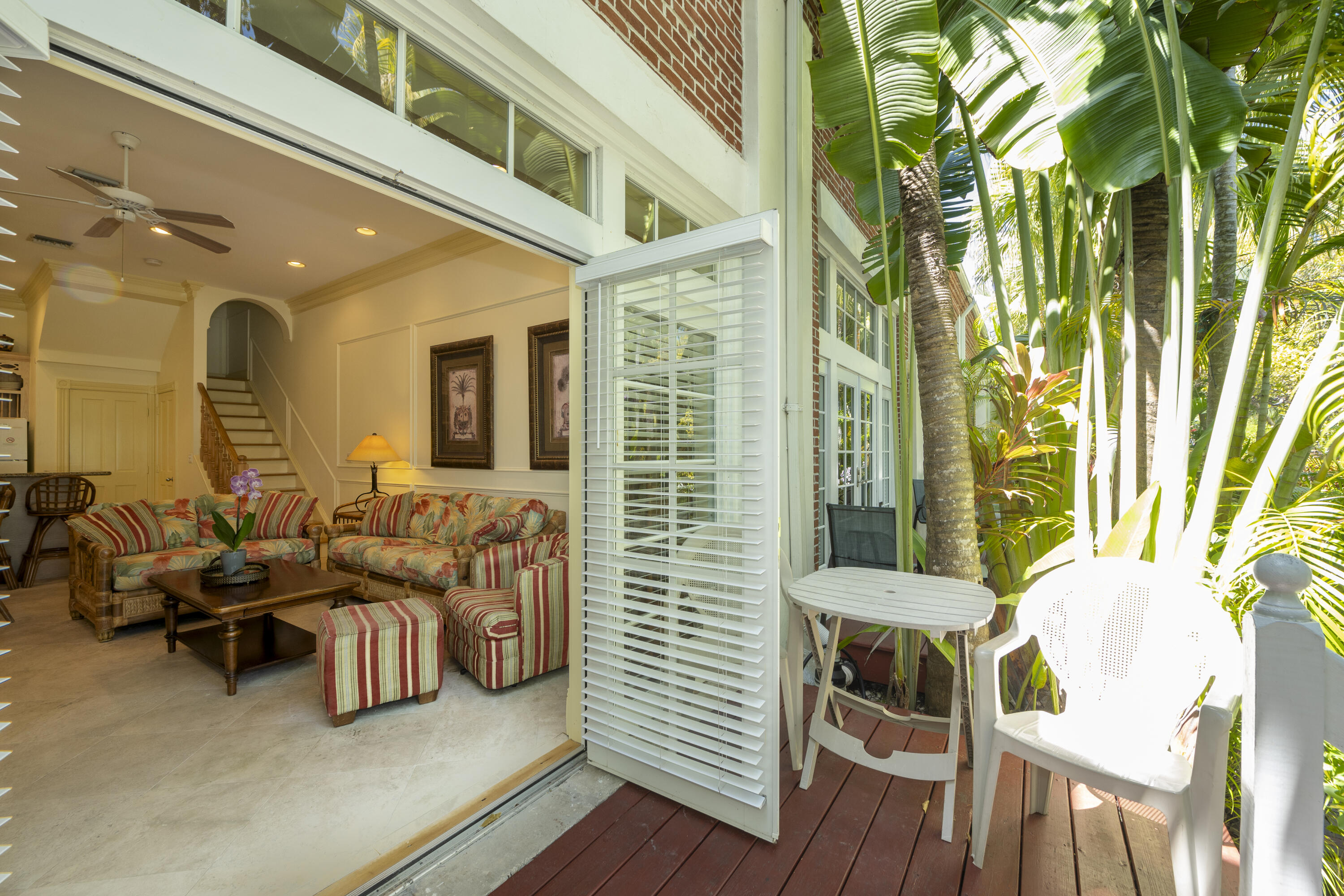 a view of a patio with couches chairs and wooden floor