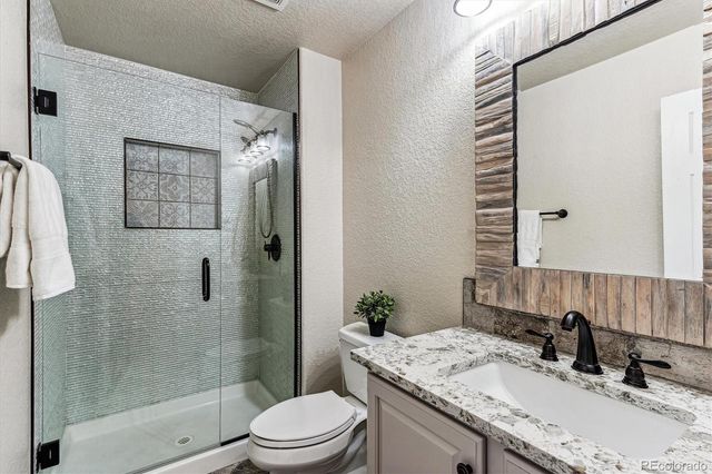 a bathroom with a granite countertop sink toilet and shower