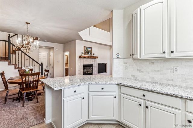 a kitchen with stainless steel appliances granite countertop a stove and a white cabinets