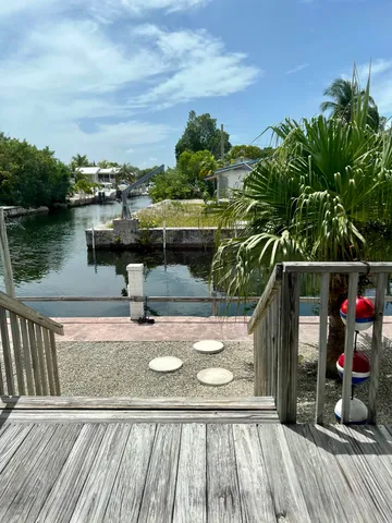 a view of a balcony with wooden floor and lake view