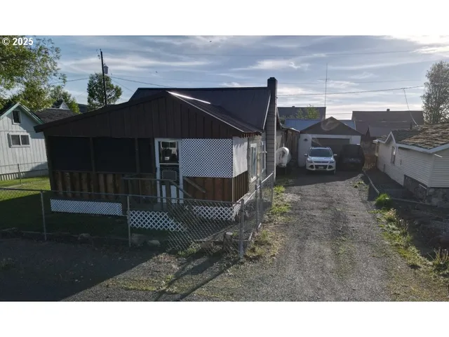 a backyard of a house with table and chairs